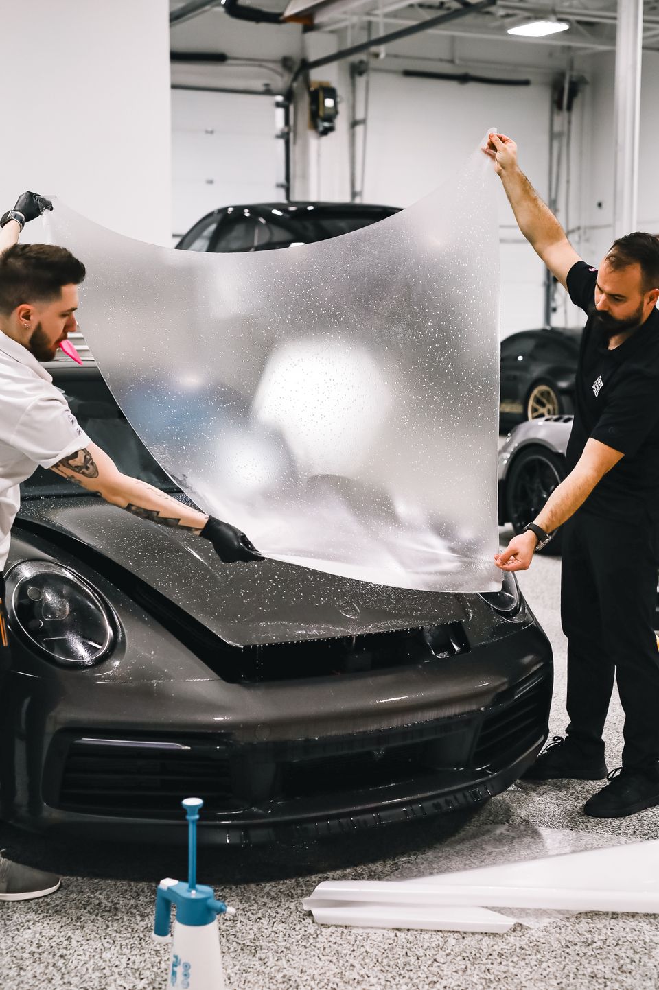 Transparente Lackschutzfolie wird auf einer Motorhaube angebracht